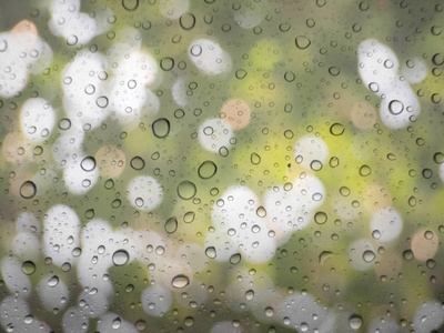 关闭玻璃背景下的雨滴。散景出焦点