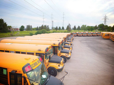 满是校车的停车场等着教育旺季。排满了许多 schoolbus 准备接学生上学。从上面的无人机鸟瞰图