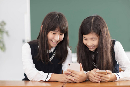 青少年女孩在教室里看智能手机