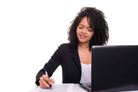 在白色背景下工作的年轻非洲女商人在笔记本电脑上
