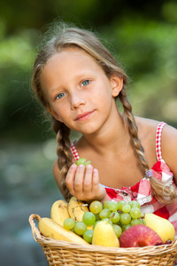 uttrycksfulla tjej dricka milkshake可爱的女孩带新鲜水果篮子户外