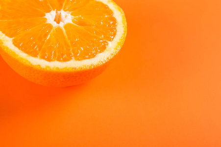 橙色背景上的半橙色水果的顶部视图照片