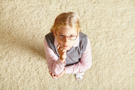 在地毯上戴眼镜的学龄儿童图片