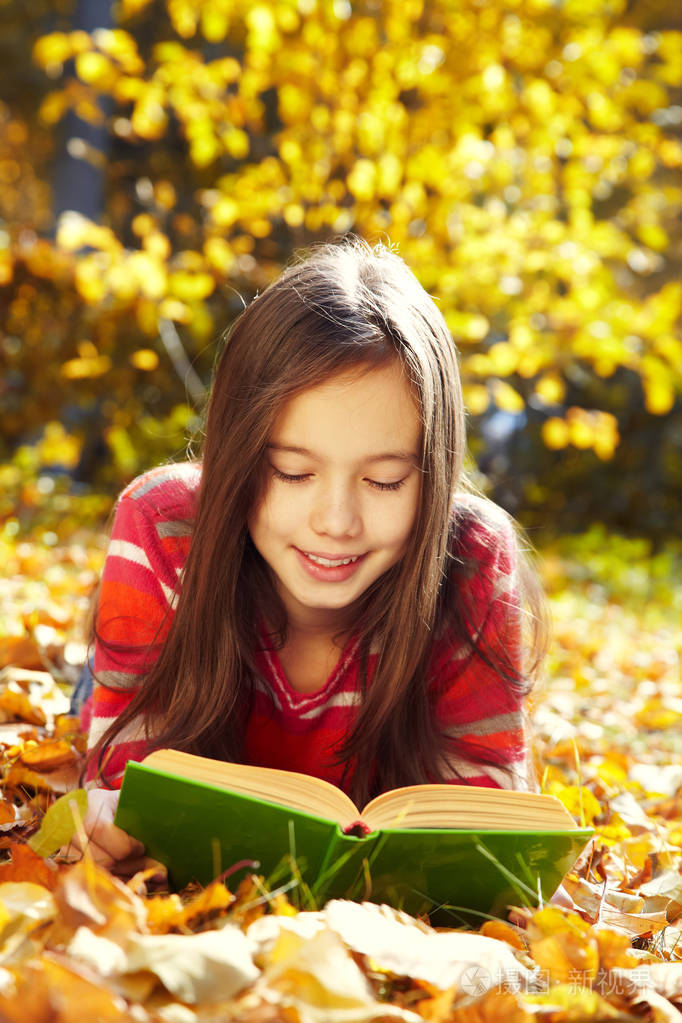 躺在落叶上看书的女孩