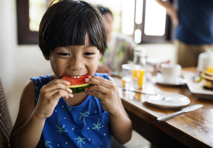 亚洲男孩在西瓜上吃零食图片