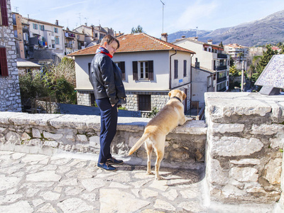 旺斯, 法国, 在2018年3月8日。这个女人和一条狗从一个在城市附近的山坡上风景如画的房子的调查网站看