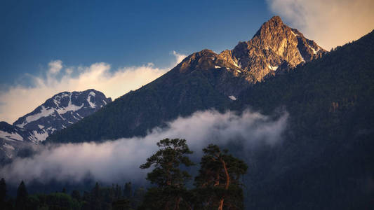 美丽的自然景观的山在日落。金色的阳光照亮了山顶