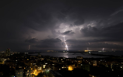 城市上空漆黑夜空中的壮观雷暴图片