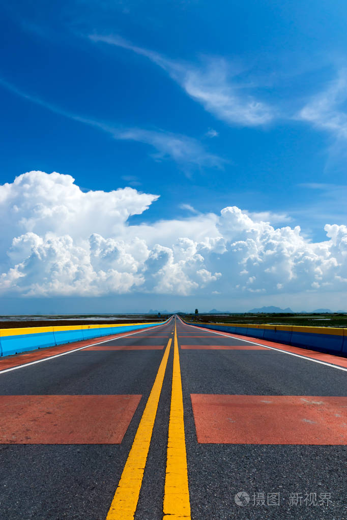 天空中的白云与空旷的道路和五颜六色的交通线