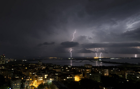 城市上空漆黑夜空中的壮观雷暴图片