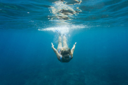 游泳衣中年轻女子的水下照片独自在海里潜水
