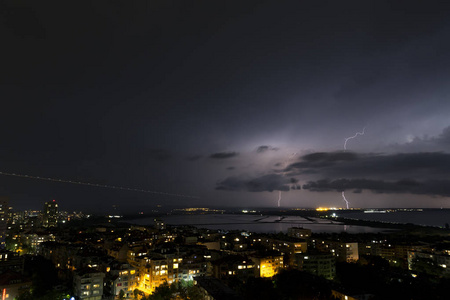 城市上空漆黑夜空中的壮观雷暴图片