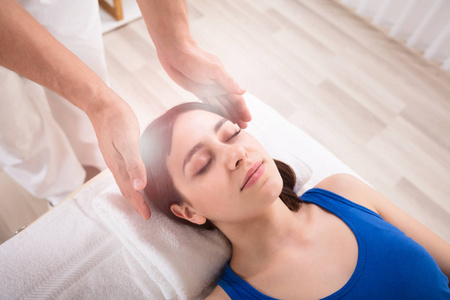 实践中心水疗中心的年轻女性理疗师手上的灵气治疗特写照片