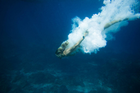 在海洋中独自潜水的年轻人的水下照片