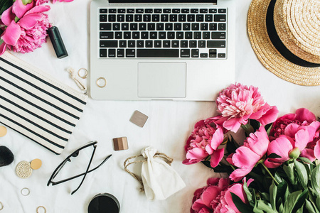 时尚女性办公桌带牡丹花, 笔记本电脑, 配件白色背景。平躺, 顶部看法静物概念