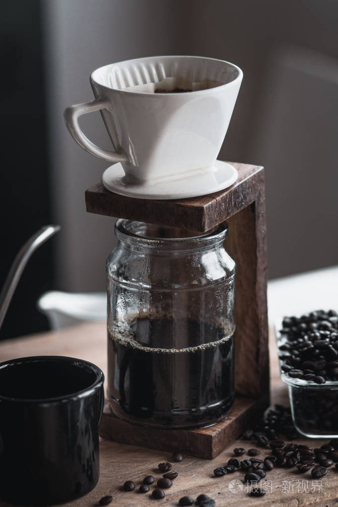 咖啡在玻璃瓶里咖啡滴水手捧水壶滴咖啡在房间里