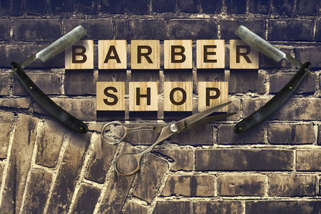 概念理发店。在旧老式墙的背景上的木质立方体上的铭文。美。时尚