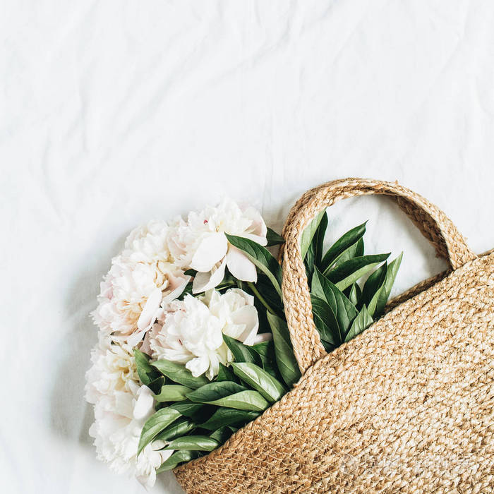白牡丹花的稻草袋, 白色的背景。平躺, 上观夏日花卉概念