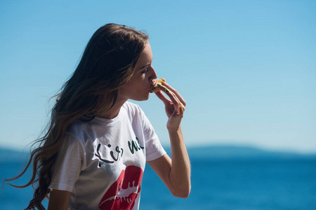 夏天在户外吃冰淇淋的年轻女孩, 在炎热的海洋背景下