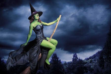 在她的扫帚飞行的万圣节女巫照片