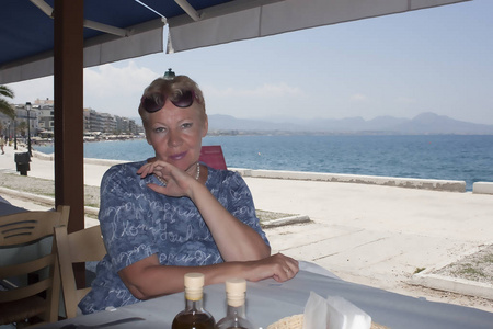 希腊路特奇海滨酒馆一张桌子上一个成熟女人的肖像