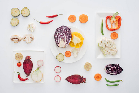 白色板和切片新鲜健康蔬菜的顶部视图