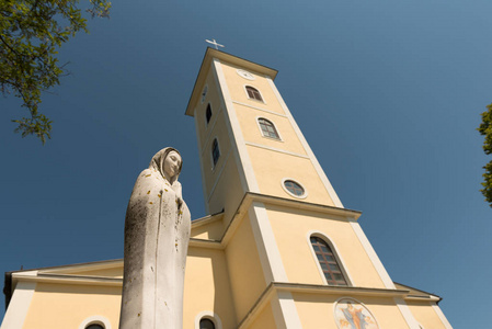 克罗地亚 Cetingrad 的 Uznesenja Bdm 教堂。新的教会在战争以后在克罗地亚。圣母玛利亚雕像, 背景为教堂塔