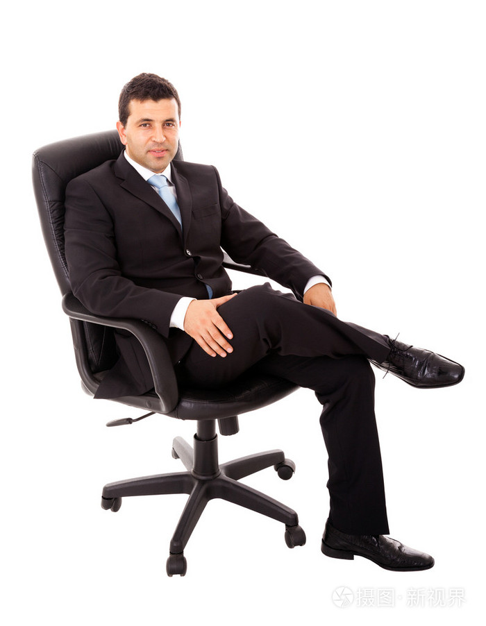 年轻商务男子坐在一把椅子和放宽白色上被孤立