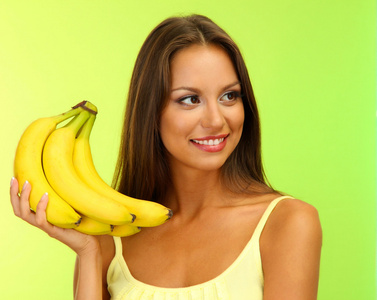 美丽的年轻女子，与香蕉 绿色背景