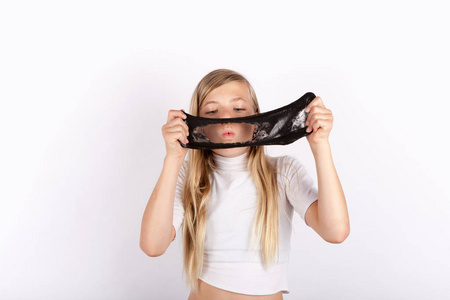 滑稽的女孩举行和吹一个洞到一个黑色的粘液看起来像黏糊糊的在她面前