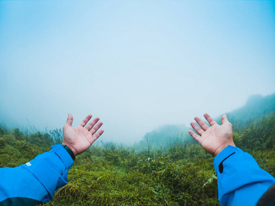 快乐的人用双臂举起, 享受美丽的热带雨林和美丽的山背景与自然风景