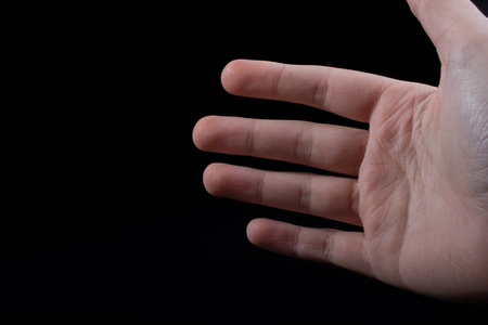 四个孩子手的手指部分被看见在黑色背景