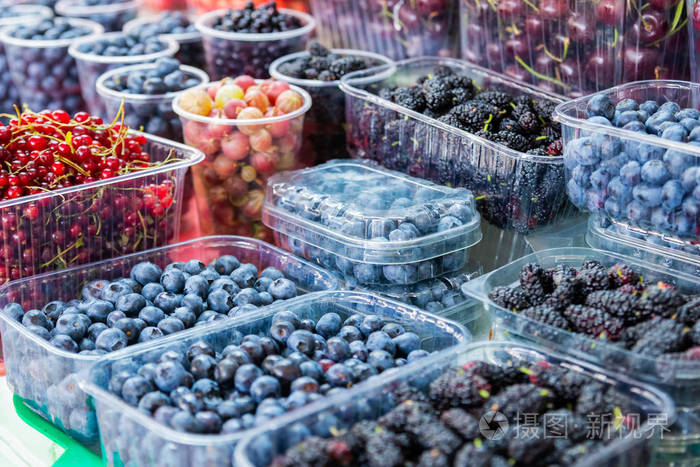 新鲜的不同浆果在塑料容器存放在绿色杂货店天然有机食品成分的健康