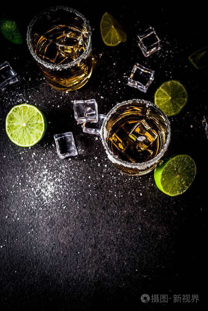 两杯龙舌兰酒在黑暗背景下拍摄, 冰块, 盐和石灰复制空间