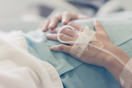 的手, 照顾老人的概念亚洲男孩躺在病床上输液泵静脉点滴医院的病床