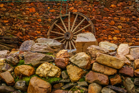 墙与砖石和木制推车轮在一个红色城市西班牙 Villacorta
