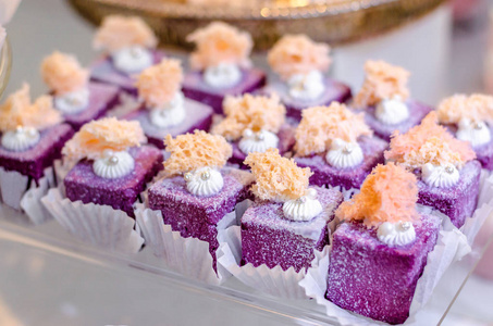 美味的婚礼接待糖果奢华的紫色甜点和可食用的珍珠和可食用的水晶宝石上的玻璃板上。糖果棒 desser