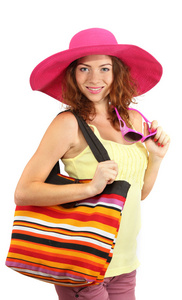 微笑的海滩帽子和包上白色隔离的漂亮女孩