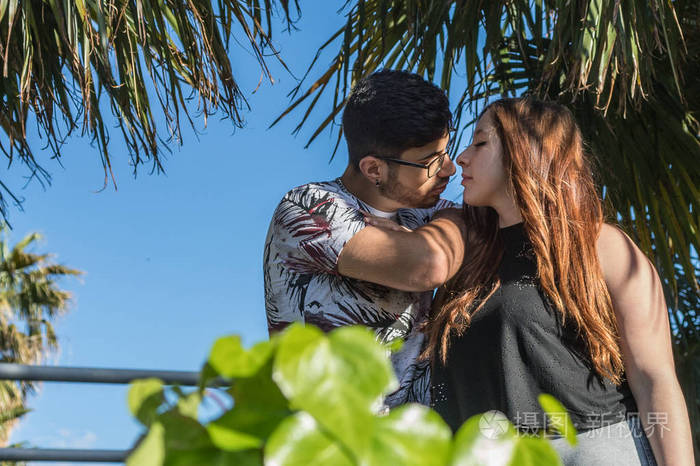 情侣在绿叶间拥抱