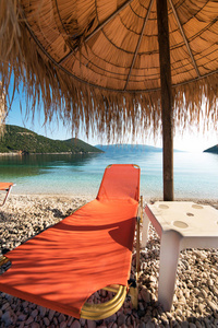 在希腊凯法利尼亚的爱奥尼亚海沿岸的 Antisamos 海滩上, 有一个橙色躺椅的抽象图像。令人惊叹的地方。旅游景点