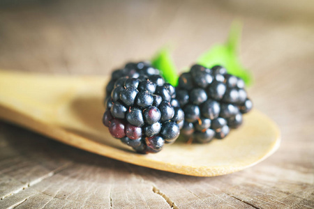 在木桌上的成熟黑莓。深色背景