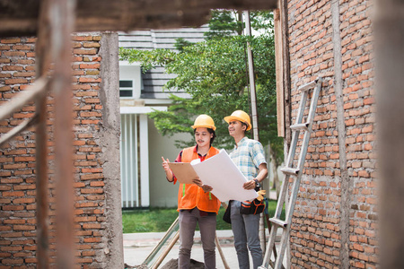 两名建筑工人站在建筑工地上