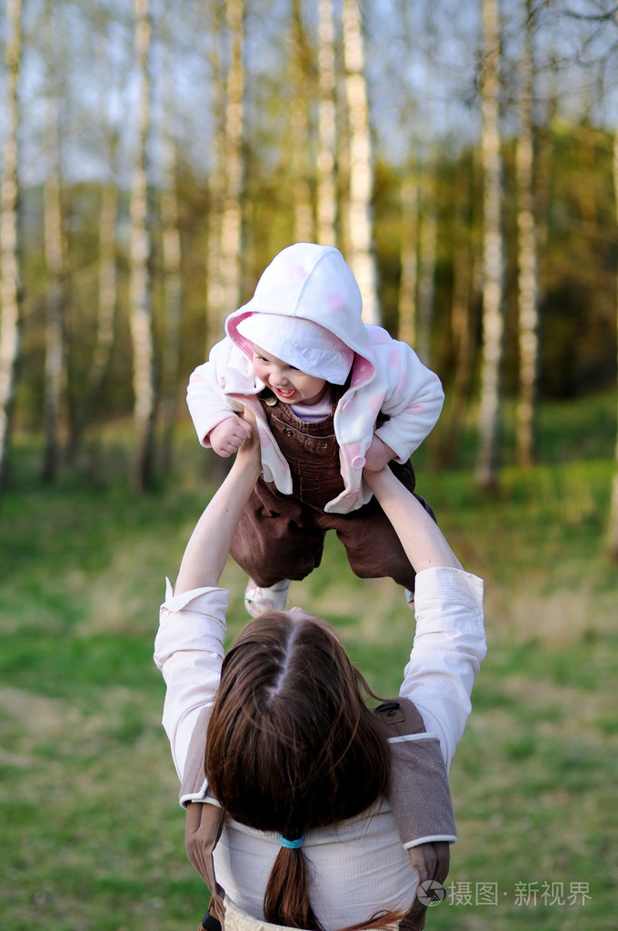 年轻的母亲抱着她的宝贝女儿