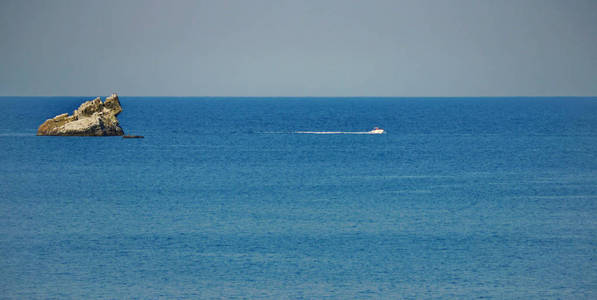 沿着一艘快艇平静的蓝色水面, 在清澈万里无云的天空下, 从岩石的海洋中凸出。休息旅行旅游和捕鱼地点