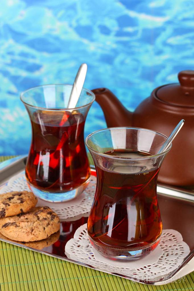 土耳其语的茶和颜色背景上的水壶玻璃