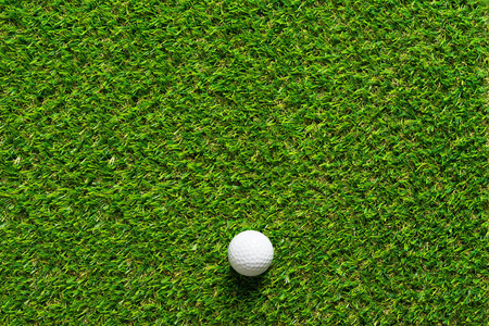 高尔夫球在绿色草纹理高尔夫球场为背景