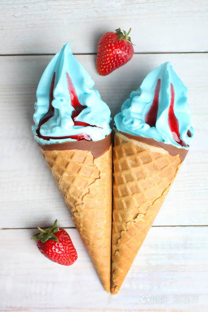 两个蓝色的冰淇淋和草莓的木质背景