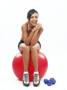 年轻女子做健身运动的一个红球