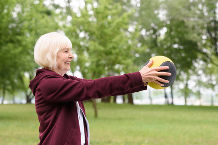 老年妇女在公园锻炼与医学球