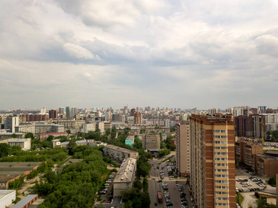 旧的和新的俄国建筑在绿色区域在城市与许多汽车。俄罗斯街头, 新西伯利亚